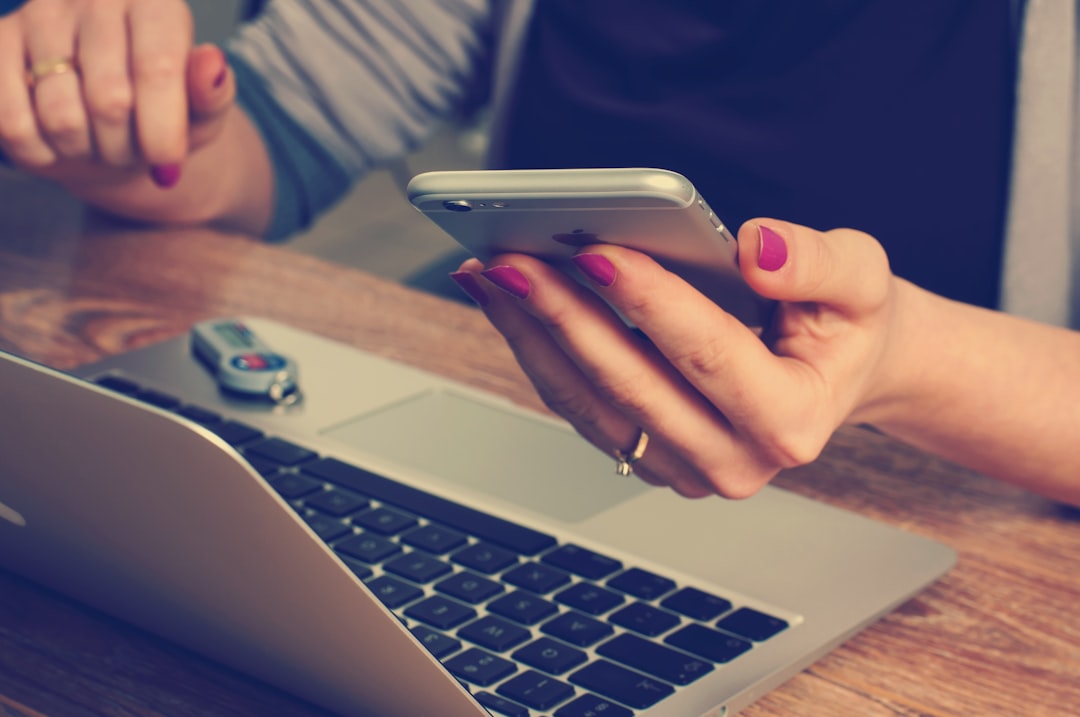 person checking budget on smartphone and laptop