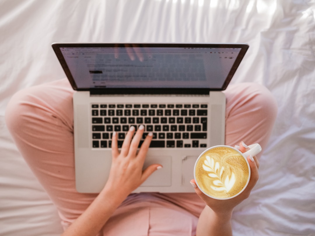 person writing resume on laptop with coffee